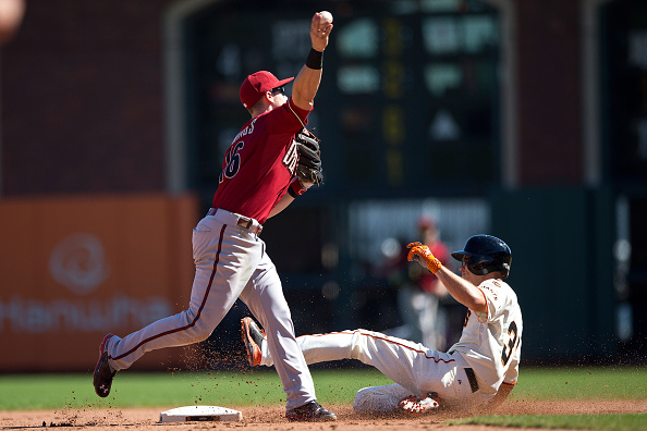 SAN FRANCISCO, CA - SEPTEMBER 20:  Chris Owings #16 of the Arizona Diamondbacks throws after forcing out Kelby Tomlinson #37 of the San Francisco Giants at second base but didn't get the double play at first base in the fifth inning at AT&T Park on September 20, 2015 in San Francisco, California. The San Francisco Giants defeated the Arizona Diamondbacks 5-1.  (Photo by Jason O. Watson/Getty Images)